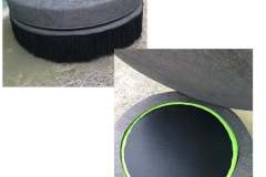 Large round dark gray ottoman with black fringe trim