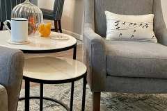 Gray accent chair with bird pillow styled in client dining area