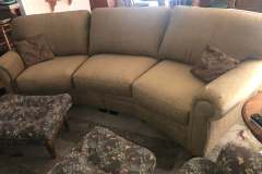 Olive green curved conversation sofa with paisley footstool in client home