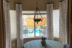 Custom floral curtain panels on bay windows in client breakfast nook