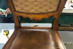 Carved dining chair with woven rattan back and leather seat