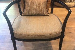 Cane-back accent chair with striped pillow in client home