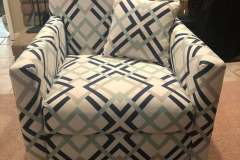 Blue and gray geometric pattern swivel chair by fireplace