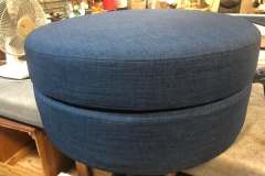 Navy blue round ottoman on worktable in shop