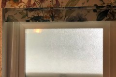 Floral valance over frosted bathroom window