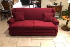 Cranberry red three-seat sofa with matching pillows in client home