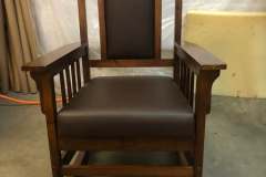 Mission-style oak rocking chair with dark brown leather upholstery