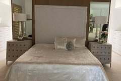 Linen upholstered king headboard with silk pillows in client master bedroom
