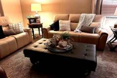 Tan leather sofa set with tufted ottoman in client living room