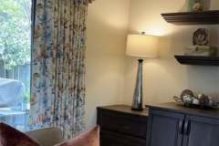 Floral curtains with velvet valance and rose pillow in client room