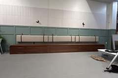 Long commercial banquette with white leather cushion in restaurant